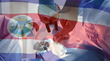 Ameliyathanede cerrahların üzerinde sallanan Corsa rica bayrağının animasyonu. küresel tıp, covid 19 pandemik konsept sırasında sağlık hizmetleri dijital olarak üretilen video.