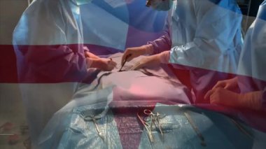 Ameliyathanede cerrahların üzerinde sallanan İngiltere bayrağının animasyonu. küresel tıp, covid 19 pandemik konsept sırasında sağlık hizmetleri dijital olarak üretilen video.