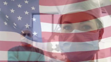 Amerika Birleşik Devletleri bayrağının ameliyathanede cerrahların üzerinde dalgalanması. küresel tıp, covid 19 pandemik konsept sırasında sağlık hizmetleri dijital olarak üretilen video.