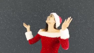 Kar yağarken Noel Baba kostümü giyen gülümseyen kadın animasyonu. Noel, kış, gelenek ve kutlama konsepti dijital olarak oluşturulmuş video.