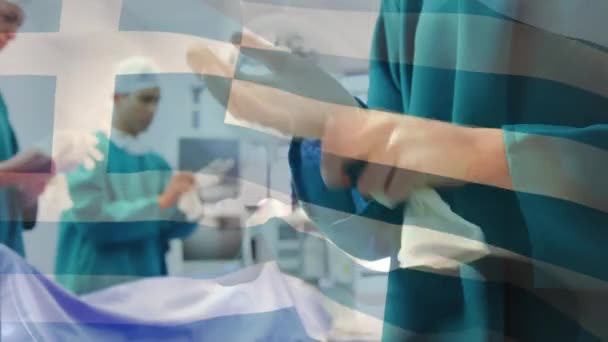 手术室里 希腊国旗在外科医生面前摇曳的动画 全球医学 围产期保健服务 数码制作的19种流行病概念视频 — 图库视频影像