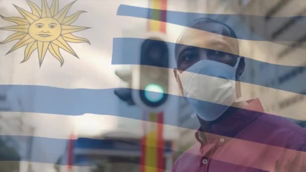 Animación Bandera Uruguay Ondeando Sobre Hombre Con Máscara Facial Durante — Vídeo de stock