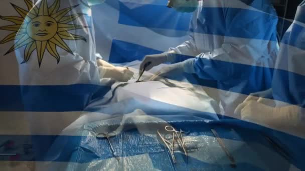 Animación Bandera Uruguay Ondeando Sobre Cirujanos Quirófano Medicina Global Servicios — Vídeo de stock