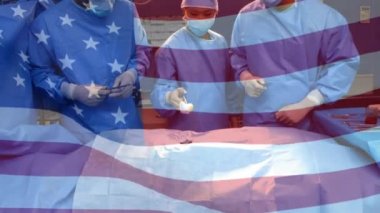 Ameliyathanede cerrahların üzerinde sallanan ABD bayrağının animasyonu. küresel tıp, covid 19 pandemik konsept sırasında sağlık hizmetleri dijital olarak üretilen video.