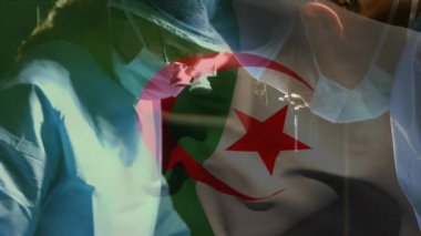 Ameliyathanede cerrahların üzerinde sallanan Cezayir bayrağının animasyonu. küresel tıp, covid 19 pandemik konsept sırasında sağlık hizmetleri dijital olarak üretilen video.