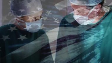 Ameliyathanede cerrahların üzerinde sallanan ABD bayrağının animasyonu. küresel tıp, covid 19 pandemik konsept sırasında sağlık hizmetleri dijital olarak üretilen video.