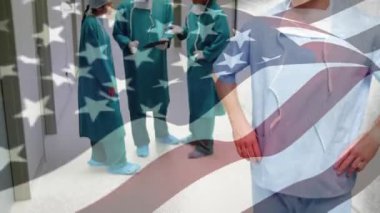 Ameliyathanede cerrahların üzerinde sallanan ABD bayrağının animasyonu. küresel tıp, covid 19 pandemik konsept sırasında sağlık hizmetleri dijital olarak üretilen video.