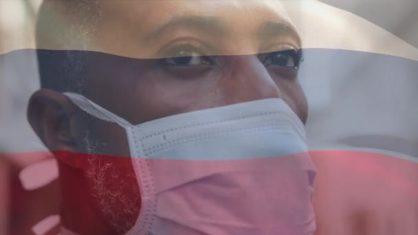 亚洲大流行期间 俄罗斯国旗在戴着面具的男人头上飘扬 全球联盟19大流行病概念数码视频 — 图库视频影像