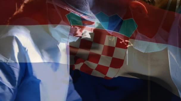 手術室の外科医に対するクロアチアの国旗のアニメーション 世界中の医療や医療サービスをデジタル化し — ストック動画