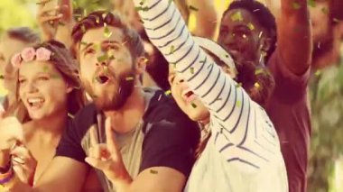 Konfetilerin müzik konserinde dans eden ve tezahürat yapan insanların üzerine düşmesi. olay, kutlama, eğlence, yaz ve müzik konsepti dijital olarak oluşturulmuş video.