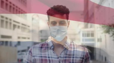 19. salgın sırasında Hollanda bayrağının maske takan adamın üzerinde dalgalanması. küresel covid 19 salgın konsepti dijital olarak oluşturulmuş video.