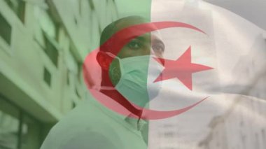 Cezayir bayrağının animasyonu. Covid 19 salgını sırasında yüz maskesi takan adamın üzerinde sallanıyor. küresel covid 19 salgın konsepti dijital olarak oluşturulmuş video.