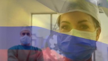 Ameliyathanede cerrahların üzerinde sallanan Kolombiya bayrağı animasyonu. küresel tıp, covid 19 pandemik konsept sırasında sağlık hizmetleri dijital olarak üretilen video.