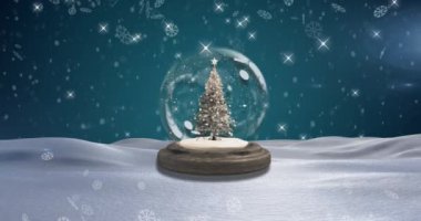 Kar taneleri, kar küresinin içinde, mavi arka planda, Noel ağacının üzerine düşüyor. Noel şenliği ve kutlama konsepti