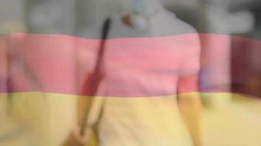 Covid 19 salgını sırasında maskeli bir adamın üzerinde sallanan Alman bayrağının animasyonu. küresel covid 19 salgın konsepti dijital olarak oluşturulmuş video.