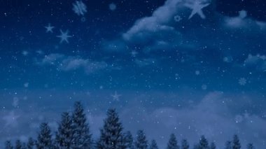 Kışın ağaçların üzerine yağan kar gece gökyüzüne çarpıyor. Noel şenliği ve kutlama konsepti