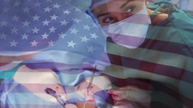 Ameliyathanede cerrahların üzerinde sallanan ABD bayrağının animasyonu. küresel tıp, covid 19 pandemik konsept sırasında sağlık hizmetleri dijital olarak üretilen video.