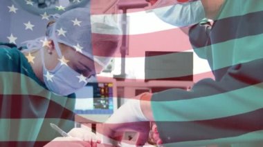 Amerika Birleşik Devletleri bayrağının ameliyathanede cerrahların üzerinde dalgalanması. küresel tıp, covid 19 pandemik konsept sırasında sağlık hizmetleri dijital olarak üretilen video.