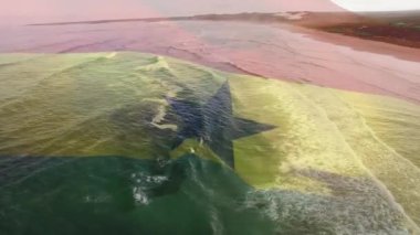 Deniz dalgalarının havadan görüntüsüne karşı Gana bayrağı sallamanın dijital bileşimi. Ulusal turizm ve seyahat kavramı