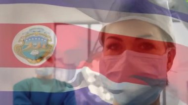 Kosta Rika bayrağının ameliyathanede cerrahların üzerinde dalgalanması. küresel tıp, covid 19 pandemik konsept sırasında sağlık hizmetleri dijital olarak üretilen video.