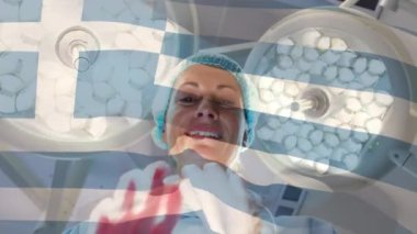 Ameliyathanede kadın cerrah üzerinde sallanan Yunan bayrağının canlandırması. küresel tıp, covid 19 pandemik konsept sırasında sağlık hizmetleri dijital olarak üretilen video.