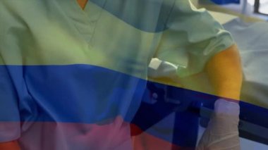 Kolombiya bayrağının maskeli bir cerrahın üzerinde dalgalanması. küresel covid 19 salgın hastalık ve sağlık hizmetleri konsepti dijital olarak oluşturulmuş video.