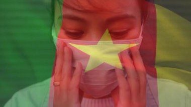 Kamerun bayrağının covid 19 salgını sırasında yüz maskesi takan kadının üzerinde dalgalanması. küresel covid 19 salgın konsepti dijital olarak oluşturulmuş video.