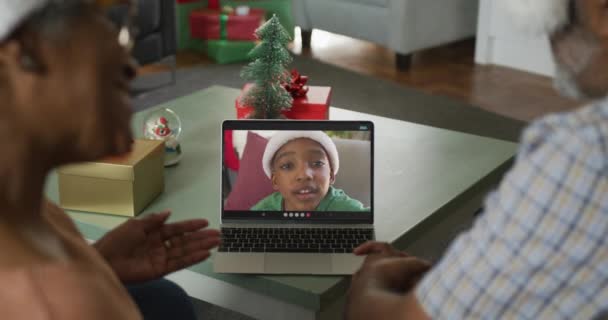 在圣诞节的时候 老非洲夫妇和孙子在笔记本电脑上通过视频通话 快乐地生活在一起 圣诞节 节日和通信技术 — 图库视频影像