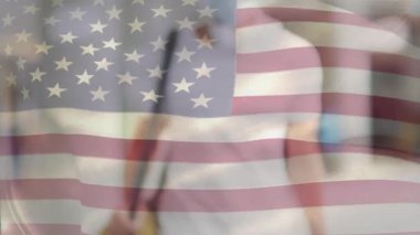Amerikan bayrağının, covid 19 salgını sırasında yüz maskesi takan adamın üzerinde dalgalanması. küresel covid 19 salgın konsepti dijital olarak oluşturulmuş video.