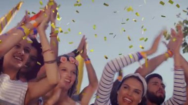 Konfetilerin müzik konserinde dans eden ve tezahürat yapan insanların üzerine düşmesi. olay, kutlama, eğlence, yaz ve müzik konsepti dijital olarak oluşturulmuş video.