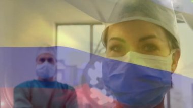 Ameliyathanede cerrahların üzerinde sallanan Kolombiya bayrağı animasyonu. küresel tıp, covid 19 pandemik konsept sırasında sağlık hizmetleri dijital olarak üretilen video.