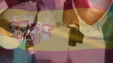 Ameliyathanede cerrahların üzerinde İspanya bayrağı animajı. küresel tıp, covid 19 pandemik konsept sırasında sağlık hizmetleri dijital olarak üretilen video.