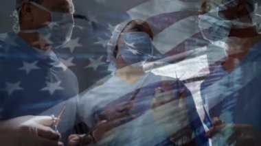 Ameliyathanede cerrahların üzerinde sallanan ABD bayrağının animasyonu. küresel tıp, covid 19 pandemik konsept sırasında sağlık hizmetleri dijital olarak üretilen video.
