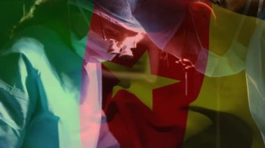 Ameliyathanede cerrahların üzerinde sallanan kamerun bayrağının animasyonu. küresel tıp, covid 19 pandemik konsept sırasında sağlık hizmetleri dijital olarak üretilen video.