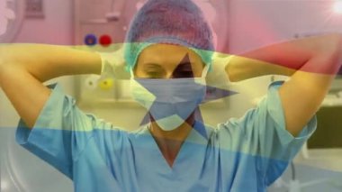 Ameliyathanede cerrahların üzerinde sallanan Gana bayrağının animasyonu. küresel tıp, covid 19 pandemik konsept sırasında sağlık hizmetleri dijital olarak üretilen video.