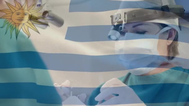 Animación Bandera Uruguay Ondeando Sobre Cirujanos Quirófano Medicina Global Servicios — Vídeo de stock