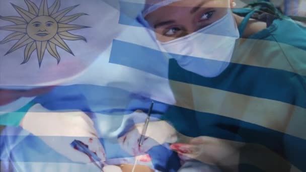 Animacja Flagi Urugwaju Machającego Nad Chirurgami Sali Operacyjnej Globalna Medycyna — Wideo stockowe