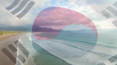 Güney Kore bayrağını sahilin ve denizin havadan görüntüsüne karşı dalgalandırmanın dijital bileşimi. Ulusal turizm ve seyahat kavramı