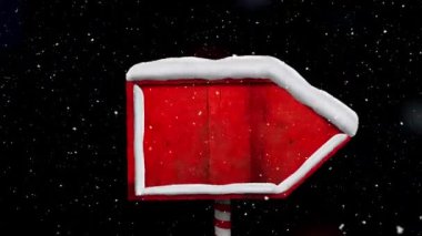 Siyah arka planda kırmızı tahta levha direğinin üzerine kar yağıyor. Noel şenliği ve kutlama konsepti