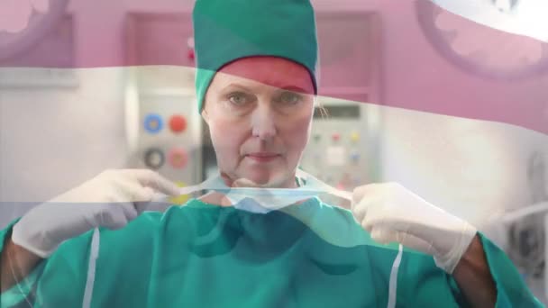 在手术室里 在女外科医生面前摇曳着的腹地旗帜的动画 全球医学 围产期保健服务 数码制作的19种流行病概念视频 — 图库视频影像