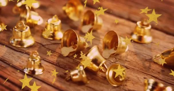Animation Von Sternen Die Über Weihnachtsglockenschmuck Auf Einer Holzoberfläche Fliegen — Stockvideo
