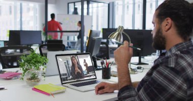 Orta Doğulu bir adam, ofisteki iş arkadaşıyla bilgisayarla görüntülü konuşma yapıyor. iş, profesyonellik ve ofis kavramı