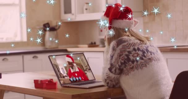 圣诞前夕 在笔记本电脑视频通话中 白雪飘落在戴着圣诞礼帽的高加索女人身上的动画 圣诞节 传统和庆祝概念数字制作的视频 — 图库视频影像
