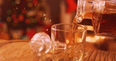 Bir bardak brendi ve noel ağacının üzerine düşen parlayan yıldızların animasyonu. Noel, gelenek ve kutlama konsepti dijital olarak oluşturuldu.