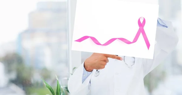 医者は病院で顔にピンクのリボンをつけたプラカードを持っている 医療と乳がん意識の概念は — ストック写真