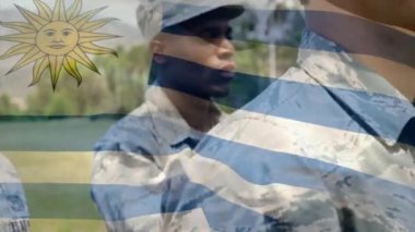 Çeşitli askerlerin üzerinde dalgalanan uruguay bayrağının animasyonu. Silahlı kuvvetler, kamu savunması, vatanseverlik ve bağımsızlık kavramı dijital olarak oluşturulmuş video.