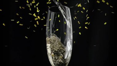 Şampanya kadehinin üzerine siyah arka planda düşen altın konfetilerinin animasyonu. Yılbaşı partisi kutlaması konsepti dijital olarak oluşturulmuş video.