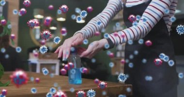 Kafkas kadın kuaför elleri dezenfekte ederken koronavirüs hücrelerinin animasyonu. Sayısal olarak üretilen covid 19 pandemik konsepti sırasında kuaförlük.