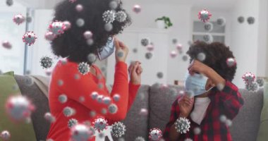 Yüz maskesi takan anne ve oğul melezleri üzerine koronavirüs hücrelerinin animasyonu. covid 19 pandemik konsept sırasında dijital olarak üretilen tıbbi ve sağlık hizmetleri.