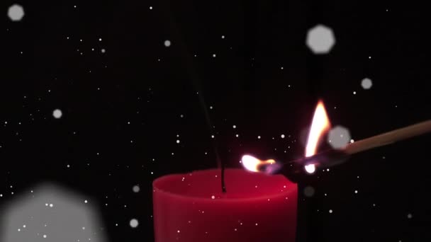 黒を背景に赤いキャンドルを照らしたマッチ棒に対して浮く白い斑点 お祭りやお祝いのコンセプト — ストック動画
